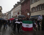 Demonstrationszug mit Iranfahne und Schirmen in der Freiburger Altstadt.