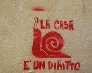 Graffiti auf einer Wand in Rot, eine Schnecke ist dargestellt, mit dem Schriftzug "La Case e un diritto"