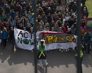 Der Demonstrationszug des Klimastreiks von oben, zwischen Brückengeländer fotografiert. Auf dem Fronttransparent steht: "Act now!" und "ÖPNV statt Stau".