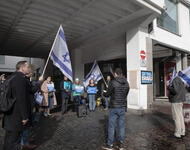 Eine Gruppe von Menschen steht im Kreis, einige von ihnen tragen Israel-Fahnen. An einer Säule der Unterführung ist ein Plakat angebracht: "Saving israeli democracy"