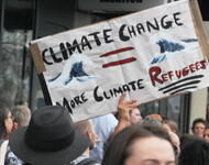 Protestschild mit der Auffschrift Climate Change = more Climate Refugees