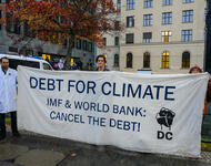 Transpi mit der Aufschrift Debt for Climate