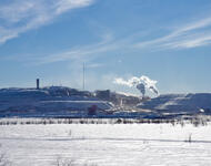 Mine bei Kiruna von Luossavaara-Kiirunavaara Aktiebolag (LKAB) einem staatlichen schwedischen Bergbauunternehmen | Eine Schneelandschaft mit blauem Himmel und einer Dunstwolke in der Ferne