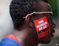Person mit einem Schild some ugandans are gay -get about it