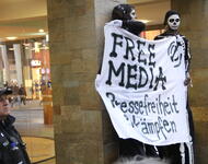 Auf Stelzen: FreeMedia Tranaparent mit Begleitenden polizisten 