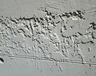 Fotografie eines Ausschnitts einer Außenwand mit klecksigem Putz.