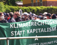 Demozug mit Banner "Klimagerechtigkeit statt Kapitalismus" bei den Aktionstagen gegen Tesla