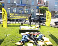 Amnesty Aktivisten liegen auf der Wiese bei einer Europaveranstaltung