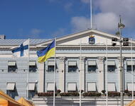 Rathaus von Helsinki mit finnischer und ukrainischer Fahne davor.