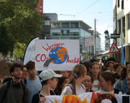 Demoteilnehmer*innen mit Schild "Weniger CO2-Ausstoß