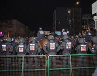 Hamburger Gitter, dahinter Spalier behelmter Polizei, 4 Polizei auf Pferden und dahinter Demonstrierende.