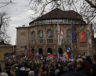 Blick auf das Stadttheater mit einer großen Menge an Demonstrierender davor. Ein orangenes Schild an der Fassade: "Nie wieder ist jetzt!"
