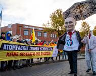 Ein Pappmaschee Putin-Kopf geht am Transpi Atomfabrik Lingen schliessen  beim rörterungstermin im November 2024 vorbei