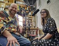 Thomas und kristina sitzen in einem Radiostudio an den Mikrofonen