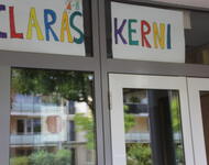 Das Gebäude an der Willi-Brandt Allee umbenant zu seinem Nutzungszweck mit einem bunten Plakat "Claras Kerni" im Haupteingang