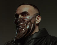 Der Rapper Médine schaut leicht zur Seite. Er hat schwarze, sehr kurze Haare und trägt eine schwarze Lederjacke. Er trägt außerdem eine braune Maske, die sein Gesicht bis seinen Augen bedeckt und undgefähjr die Form seines Gesichts hat.