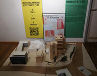 Foto aus der Ausstellung: Fix it – Umbau statt Abriss im Karlsbau. Dargestellt ist das Europaviertel - im Hintergrund findet sich ein Hinweis auf den Umbau-Atlas