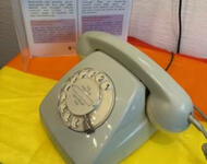 das alte wählscheiben telefon vom rosa telefon steht auf einer regenbogen flagge