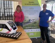 Carola Wichert und Hannes Link am Infostand zum autonom fahrenden Vehikel "Ecotrain" am Bahnhof Volgelsheim