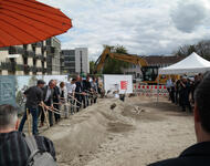 Spatenstich im Metzgergrün. Links im Bild die neuen Häuser; am Horizont hinter dem Bagger, die Reste des alten Metzgergrüns